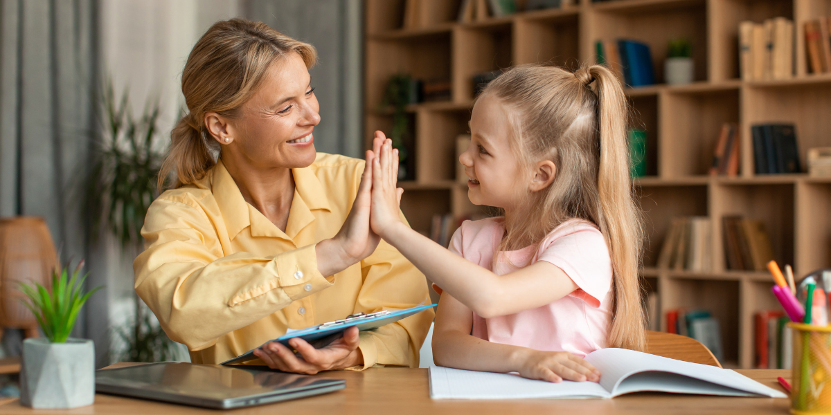 Mother giving her daughter a high five after a homeschool lesson. 