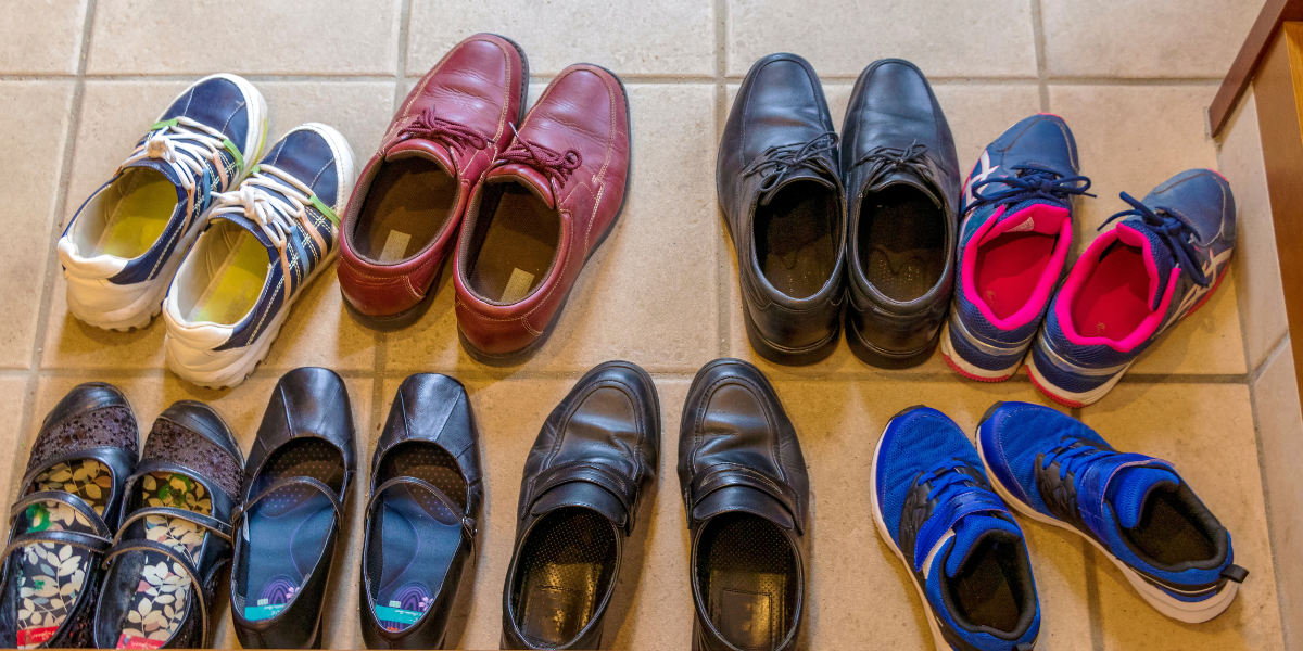 Pairs of shoes lined up on the floor. 