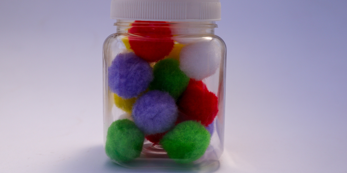 A jar of fuzzy pom-poms. 