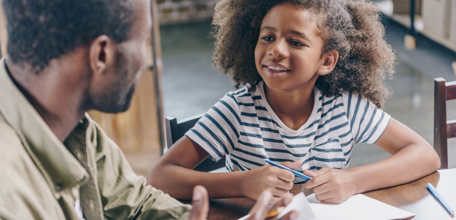 Father helping a young girl with school work. 