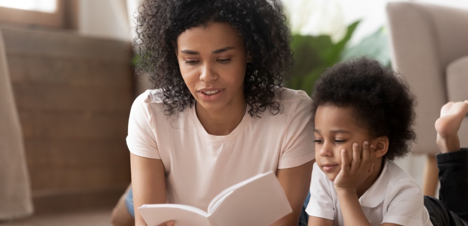 A young mom reading a book to her son. 