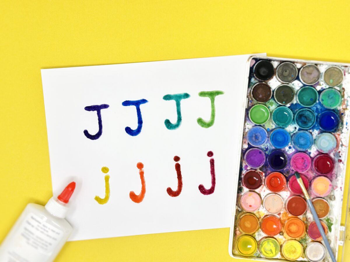 A fun painting activity with the letter J written in glue and salt them painted fun colors. 