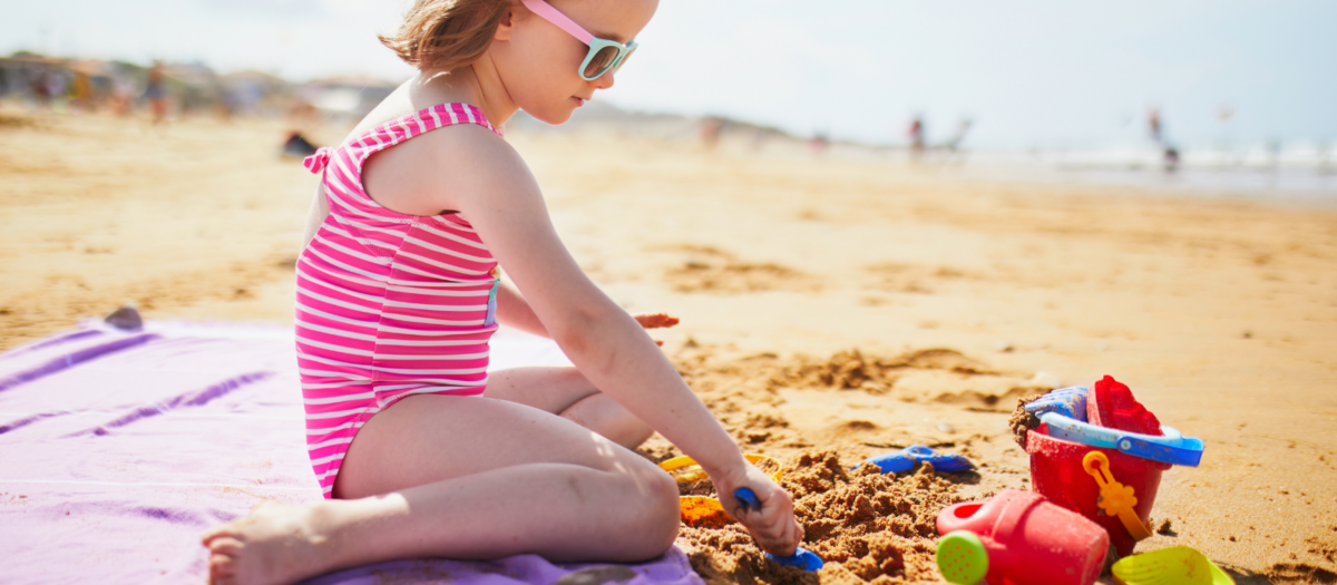 A young girl digging in the sand. 