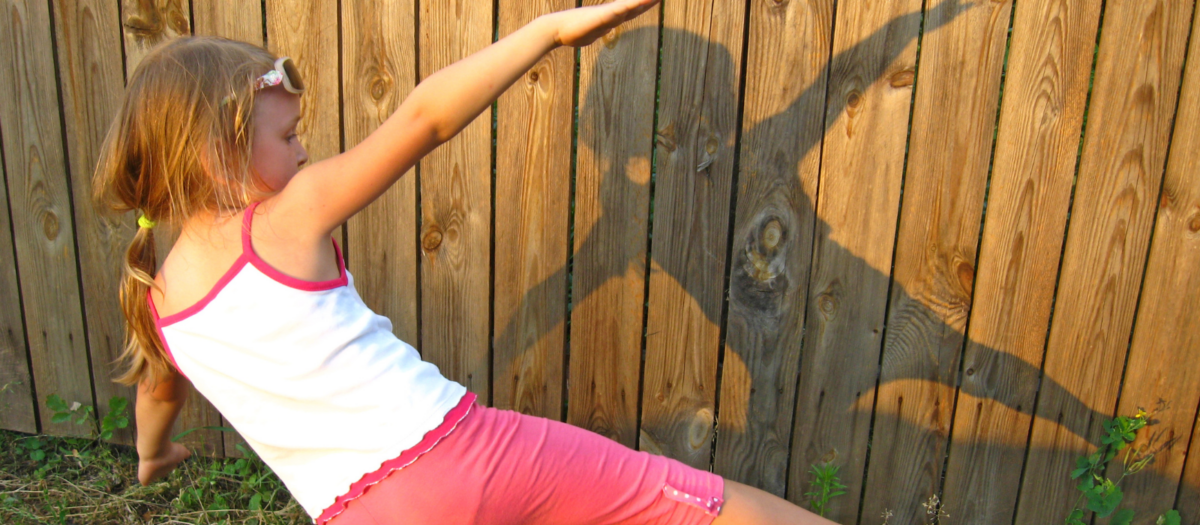 A young girl looking at her shadow and experimenting with moving around. 