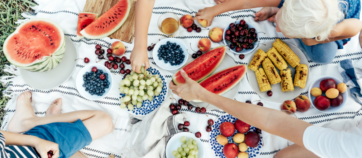 Delicious picnic foods laid out on a blanket. 