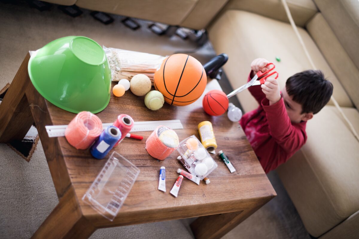 A child creating a solar system with balls. 