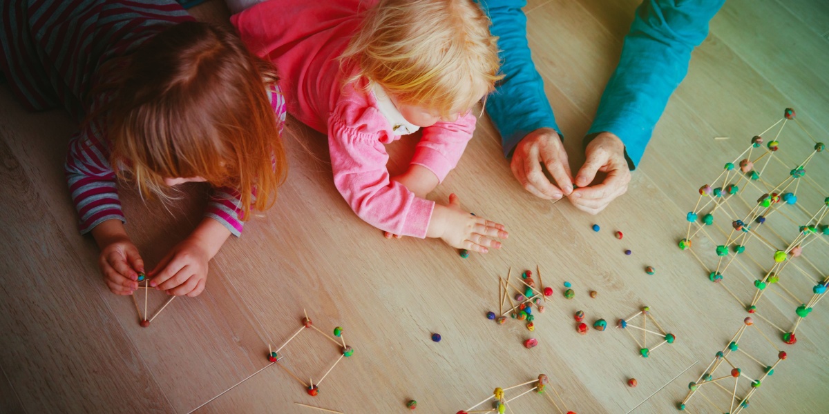 Young children playing with playdough and toothpicks.  