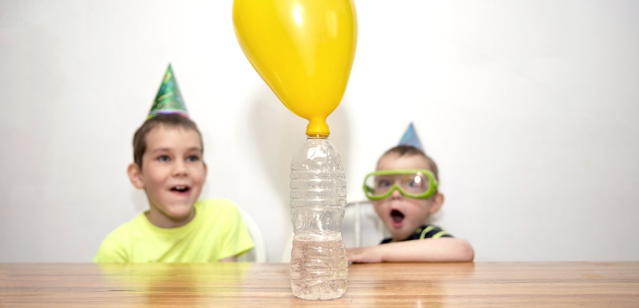 Two young boys who are very surprised at this fun balloon water bottle STEM project. 