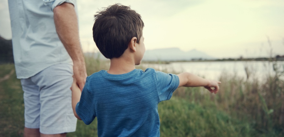 A young boy playing I spy outside with his dad. 