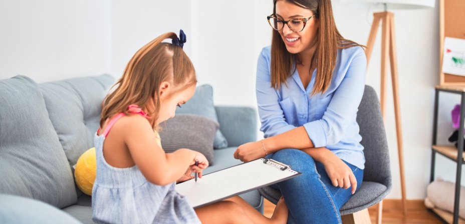 A young mom teaching her daughter to write. 