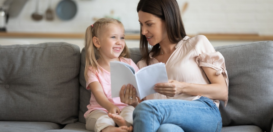 A young mom reading to her kindergartener. 