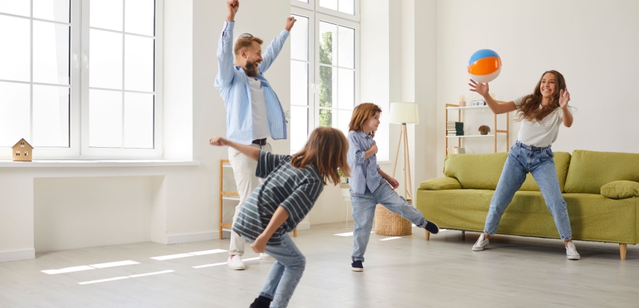 A family playing indoors with a fun beach ball. 