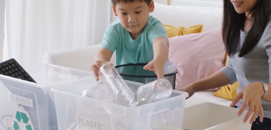 A young boy gathering plastic bottles to recycle. 