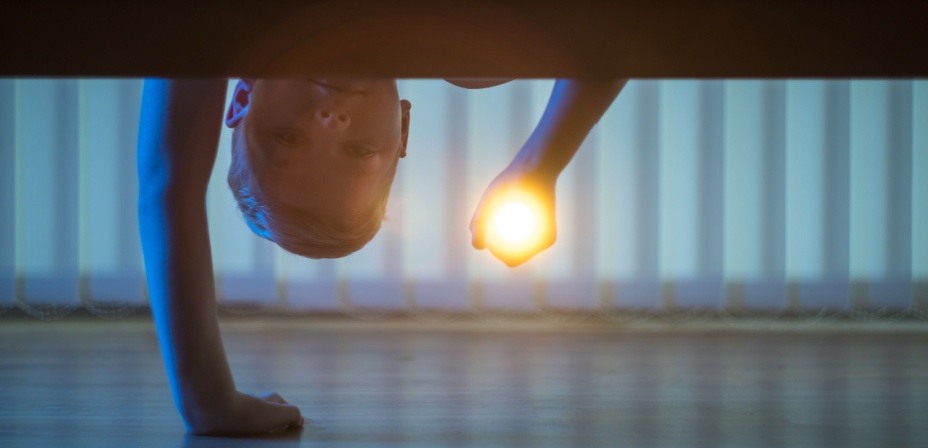 A kindergarten child playing a sight word finding game with a flashlight. 