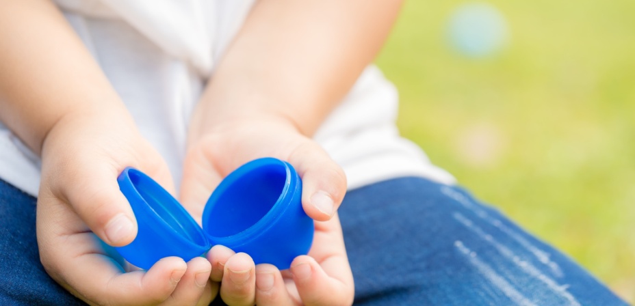 A child opening a plastic egg looking for a strip of paper that has a sight word on it. 