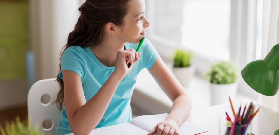 A young girl looking at the weather outside the window deciding what to write about in her STEM weather journal. 