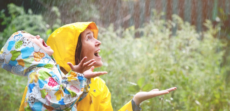 A mother and daughter having fun in the spring rain together. 