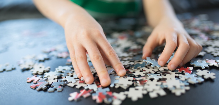 A kids hand sorting puzzle pieces. 